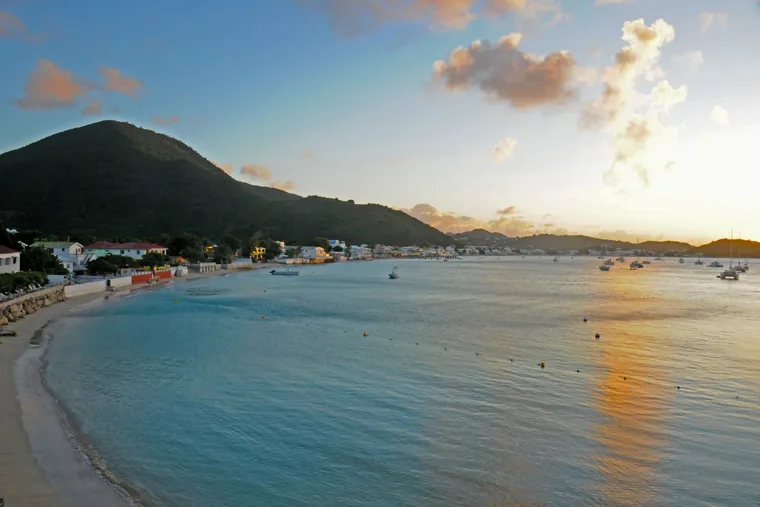 Grand Case bay and its green hill in warm evening light, Saint-Martin