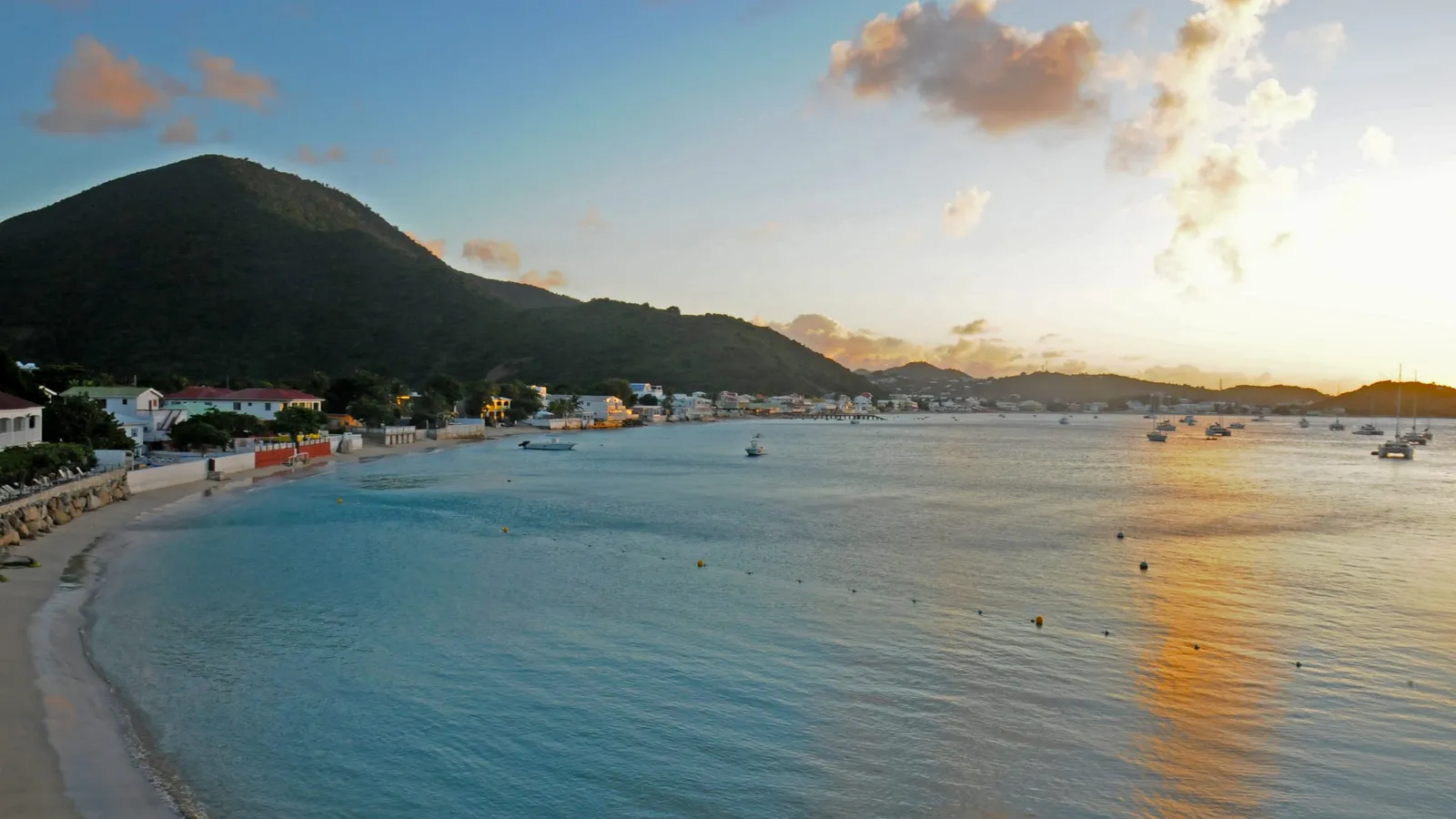Grand Case bay and its green hill in warm evening light, Saint-Martin